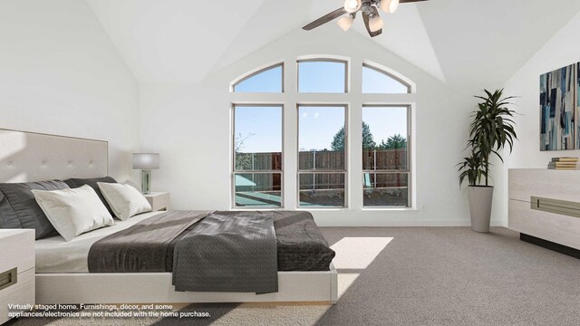 carpeted bedroom with ceiling fan and high vaulted ceiling