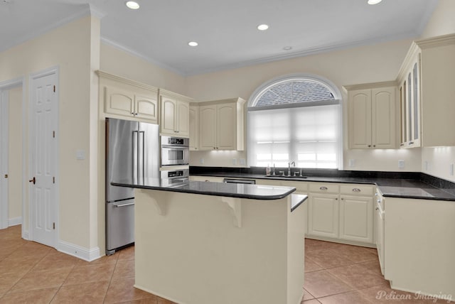 kitchen featuring sink, a center island, light tile patterned floors, high quality fridge, and ornamental molding