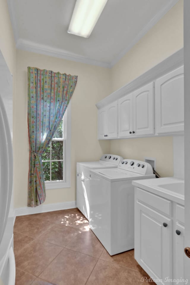 clothes washing area with light tile patterned flooring, cabinets, ornamental molding, and washing machine and dryer