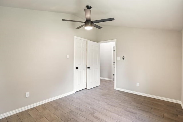 empty room with vaulted ceiling, light hardwood / wood-style flooring, and ceiling fan