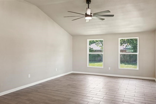 empty room featuring hardwood / wood-style flooring, ceiling fan, and vaulted ceiling