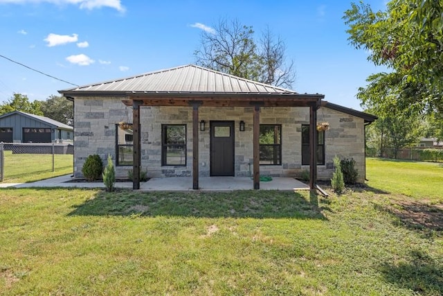 back of house with an outdoor structure, a garage, and a yard