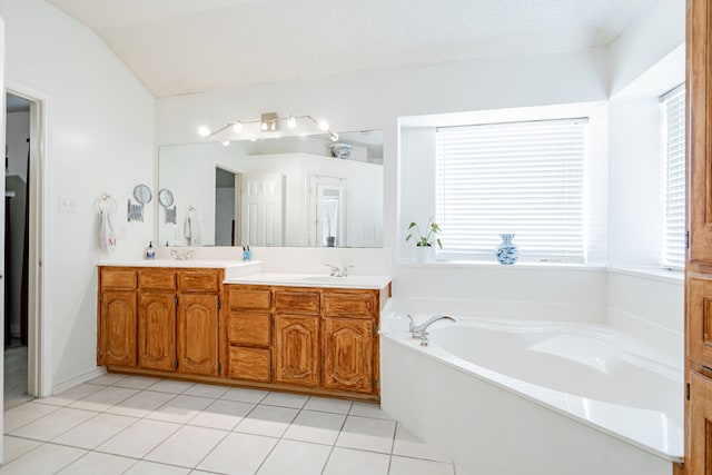 bathroom featuring lofted ceiling, tile patterned floors, a bathing tub, and dual bowl vanity