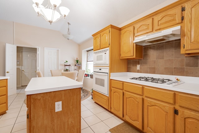 kitchen with white appliances, backsplash, lofted ceiling, a center island, and a notable chandelier