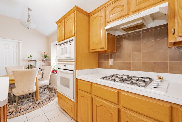 tiled dining room featuring vaulted ceiling