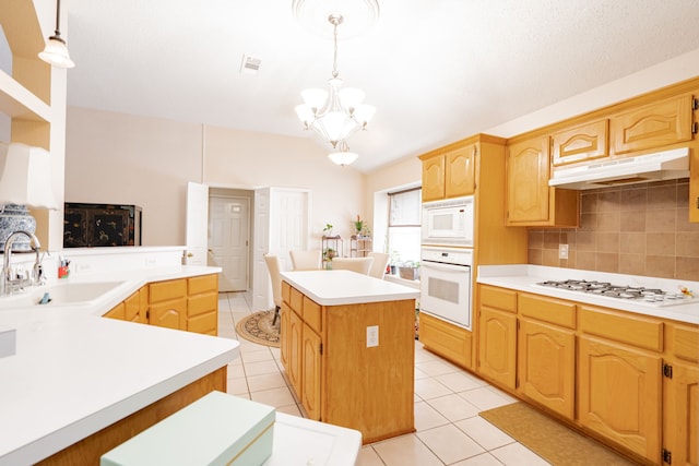 kitchen featuring tasteful backsplash, hanging light fixtures, sink, appliances with stainless steel finishes, and kitchen peninsula