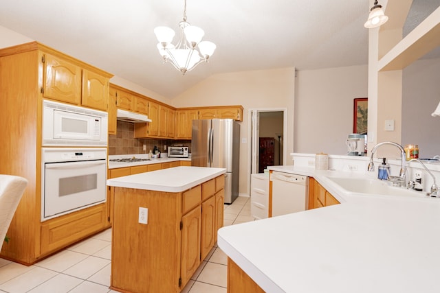 kitchen with kitchen peninsula, backsplash, appliances with stainless steel finishes, decorative light fixtures, and sink