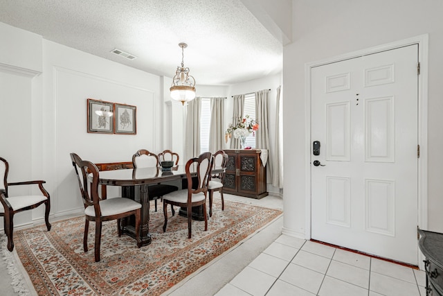 tiled dining space featuring a textured ceiling