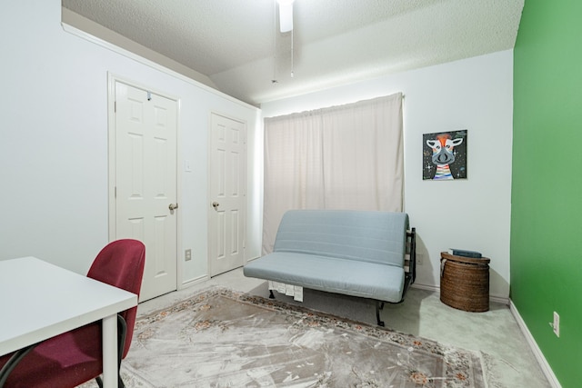 carpeted home office featuring a textured ceiling