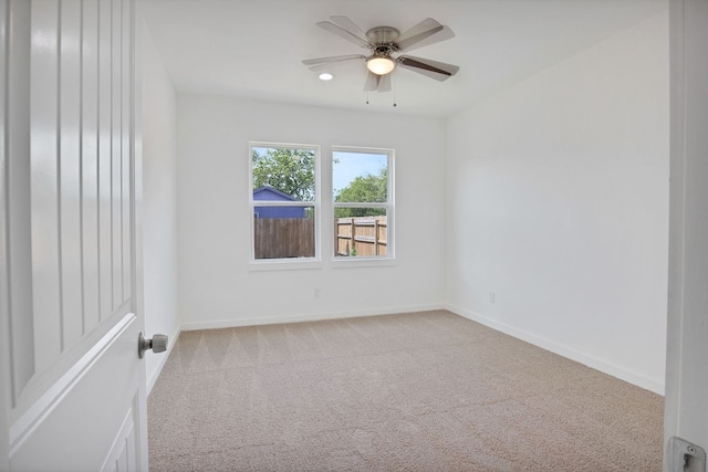 carpeted spare room with ceiling fan