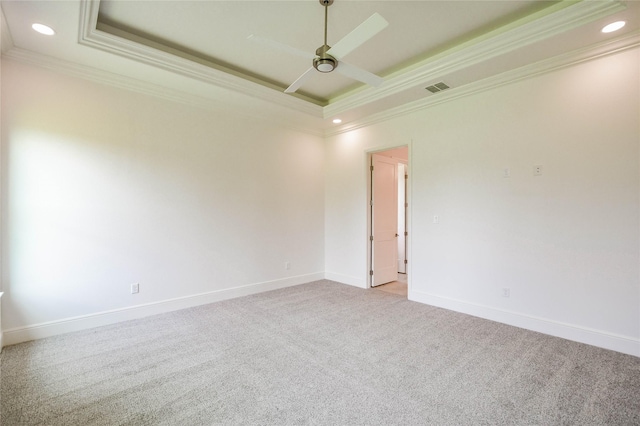 unfurnished room featuring crown molding, light colored carpet, a raised ceiling, and ceiling fan