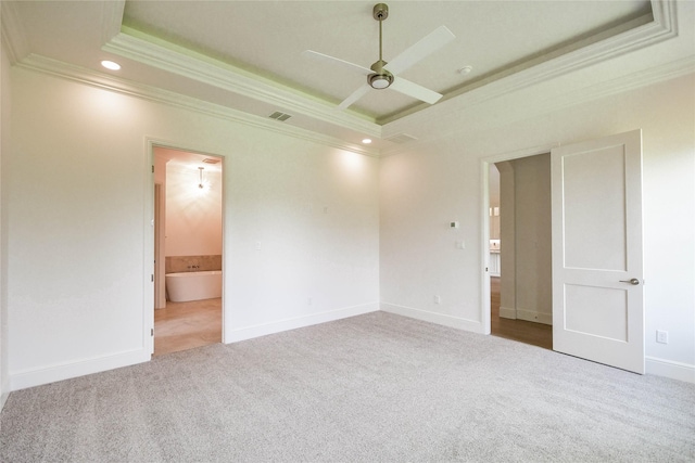 carpeted spare room with crown molding, ceiling fan, and a tray ceiling