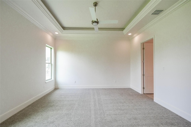 spare room with crown molding, a raised ceiling, and light carpet