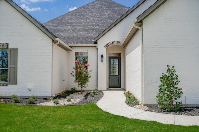 entrance to property featuring a lawn