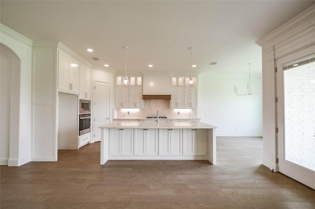 kitchen featuring white cabinetry, stainless steel appliances, dark wood-type flooring, and an island with sink