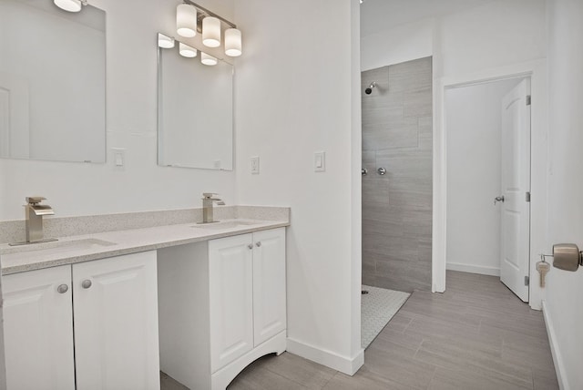 bathroom featuring a tile shower, tile patterned floors, and double sink vanity