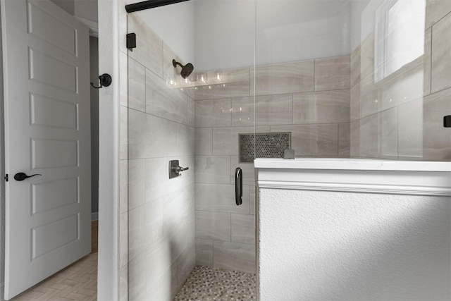 bathroom featuring a shower with door and parquet floors