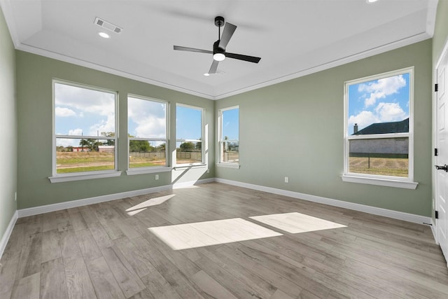 empty room featuring plenty of natural light, light hardwood / wood-style floors, ornamental molding, and ceiling fan