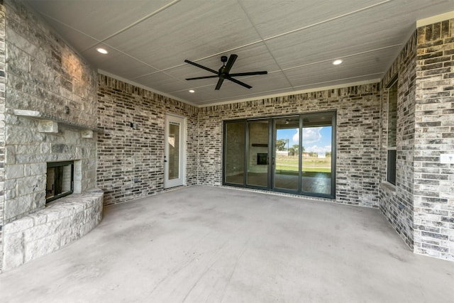 view of patio / terrace featuring an outdoor stone fireplace and ceiling fan