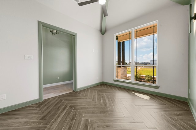 unfurnished room featuring ceiling fan and dark parquet flooring