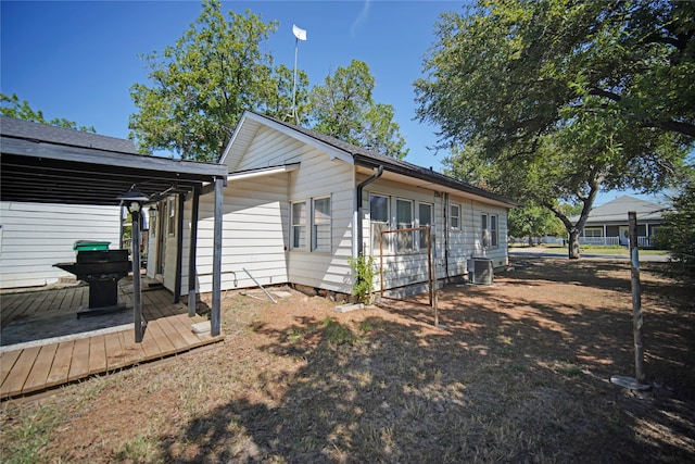 view of property exterior with central AC and a deck