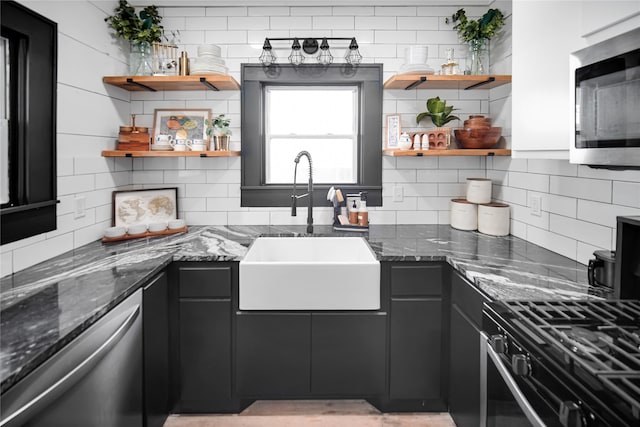 kitchen featuring dark stone countertops, sink, decorative backsplash, and appliances with stainless steel finishes