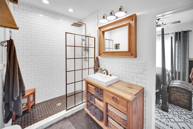 bathroom featuring vanity, tile patterned floors, ceiling fan, tile walls, and a shower with shower door