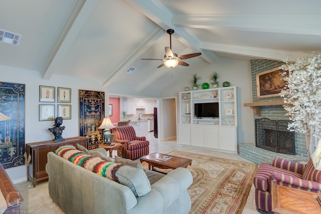 living room featuring ceiling fan, a fireplace, lofted ceiling with beams, and light tile patterned floors