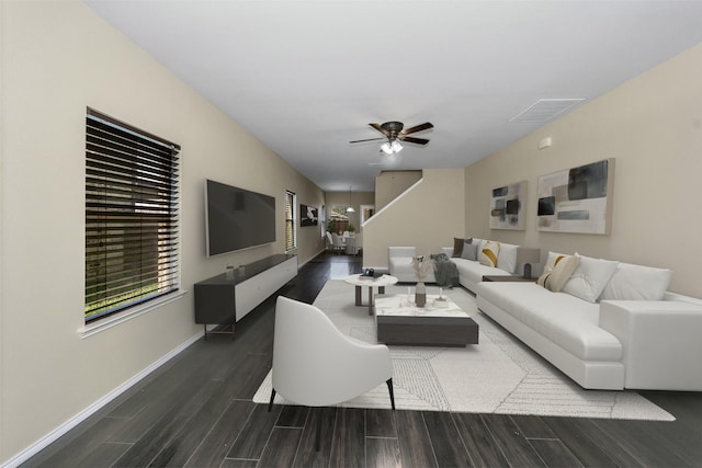 living room featuring dark wood-type flooring and ceiling fan