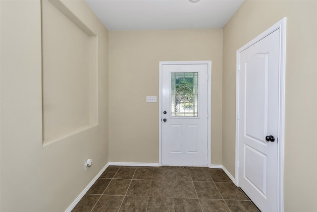 doorway with dark tile patterned flooring