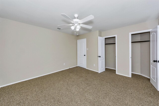 unfurnished bedroom featuring multiple closets, carpet floors, and ceiling fan