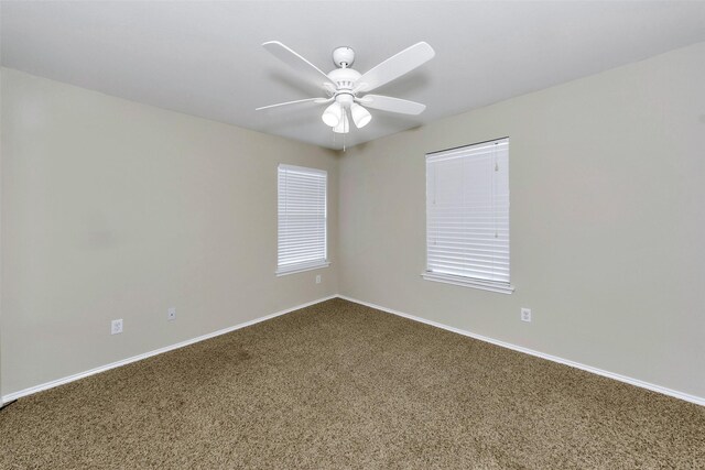 carpeted spare room featuring ceiling fan