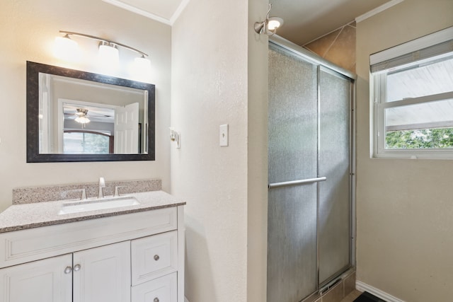 bathroom with vanity, a shower with door, and crown molding