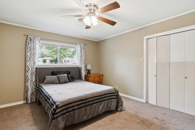 carpeted bedroom featuring a textured ceiling, crown molding, a closet, and ceiling fan