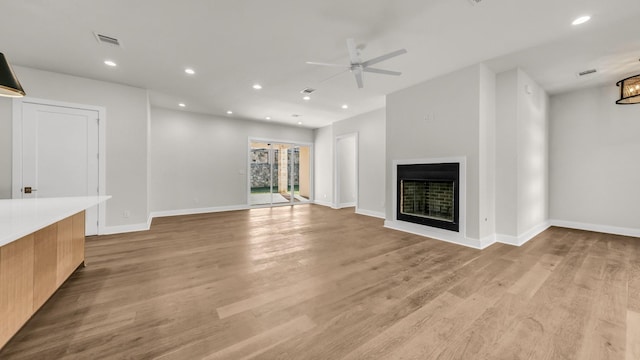 unfurnished living room featuring ceiling fan and light wood-type flooring