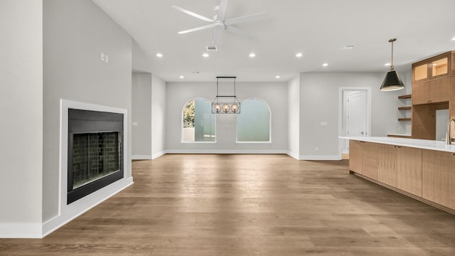 unfurnished living room featuring hardwood / wood-style floors and ceiling fan