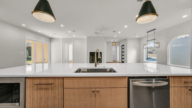 kitchen with stainless steel appliances, sink, ceiling fan, and a large island