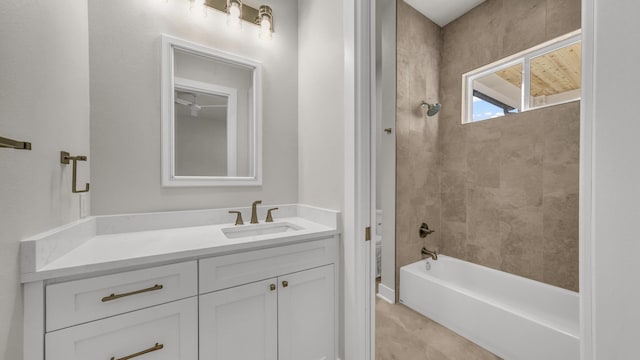 bathroom featuring tiled shower / bath and vanity