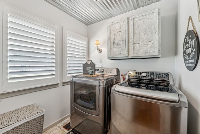 laundry room with washer and dryer and light tile patterned floors