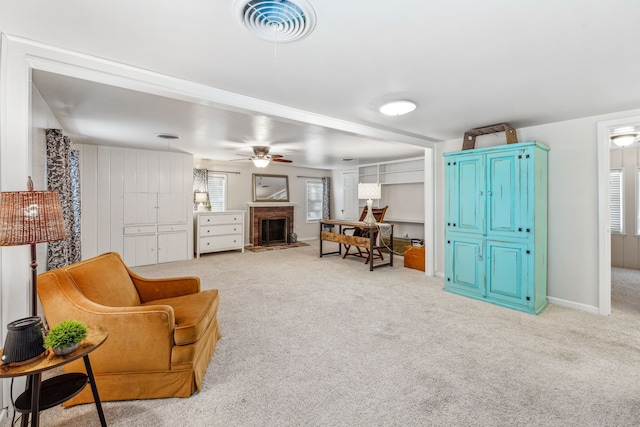 living area featuring light colored carpet and ceiling fan