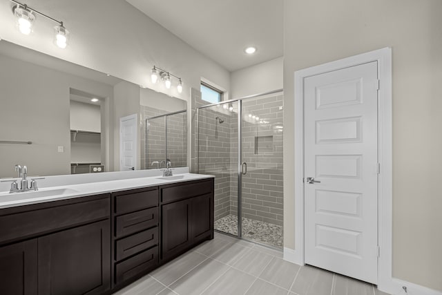 bathroom featuring a shower with door, vanity, and tile patterned floors