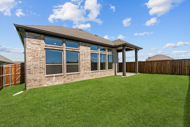 rear view of property featuring a lawn