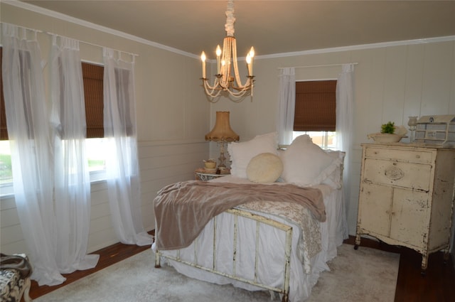 bedroom with wood-type flooring, crown molding, and an inviting chandelier