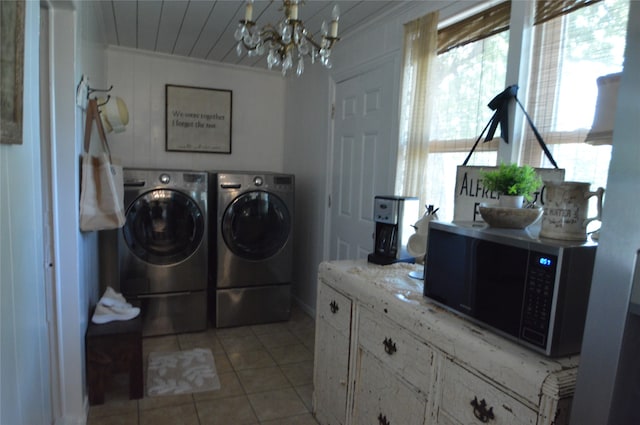 laundry room featuring an inviting chandelier, light tile patterned flooring, washer and dryer, and crown molding