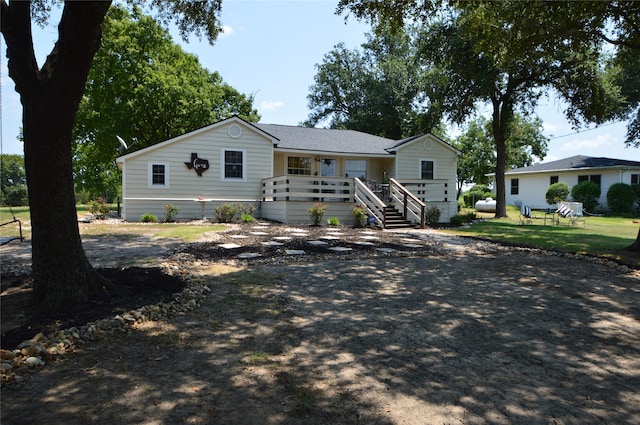 view of front of house featuring a deck and a front yard