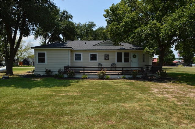 back of property featuring a deck and a lawn