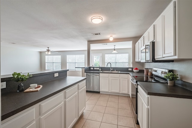 kitchen featuring stainless steel appliances, white cabinets, sink, light tile patterned floors, and ceiling fan