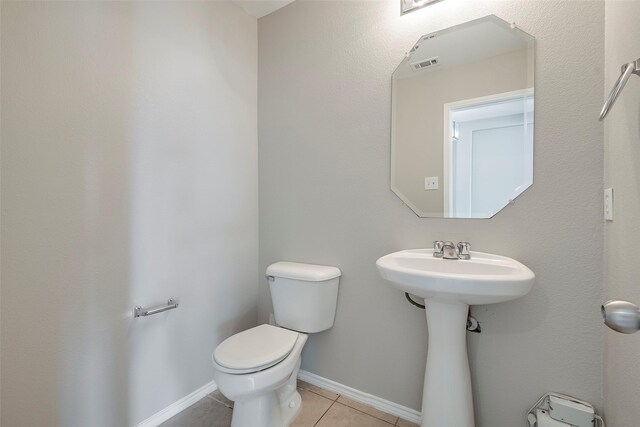 bathroom with toilet and tile patterned flooring