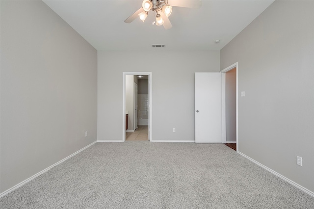 unfurnished bedroom featuring visible vents, ceiling fan, baseboards, light carpet, and ensuite bath