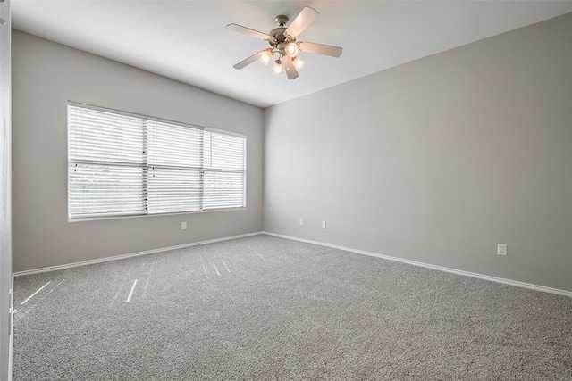 carpeted empty room featuring ceiling fan